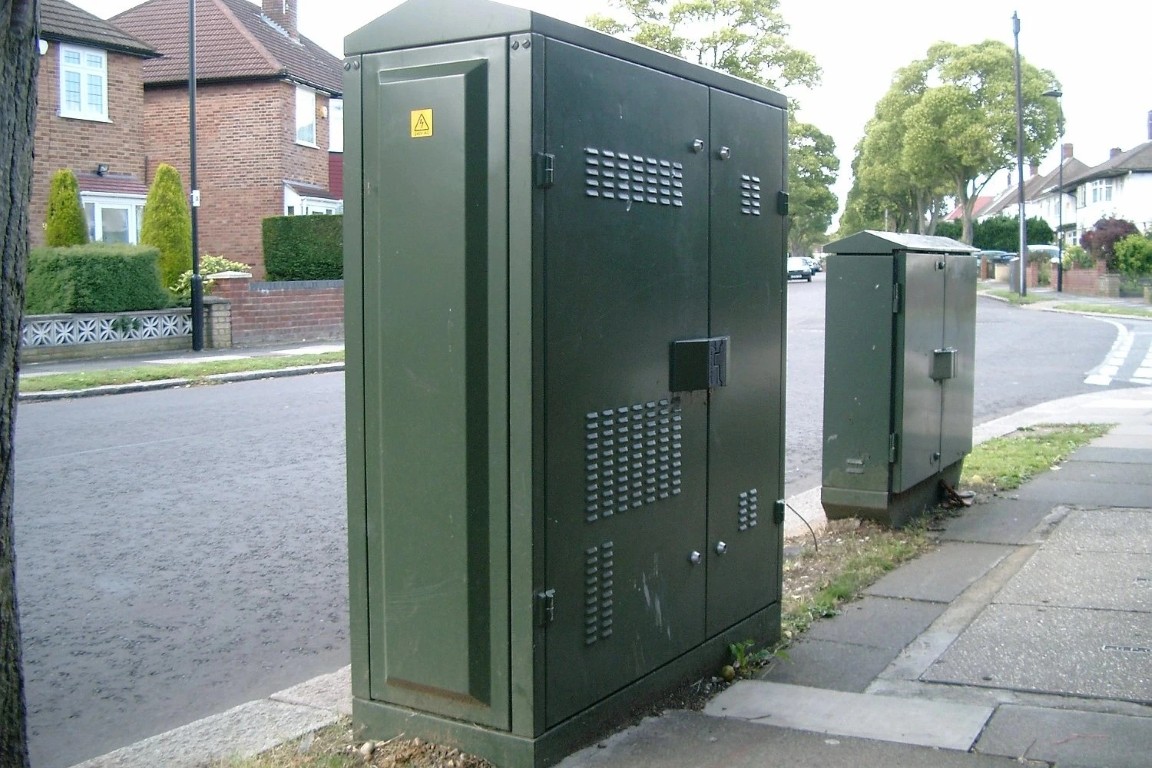 Two green cabinets by the side of the road